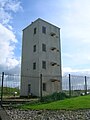 The side facing the sea with the 'hooded' light housings and part of the old 'black balls' mast lying on the ground.