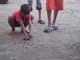 H-21 (Marbles) A game of marbles in progress on a Mumbai street.