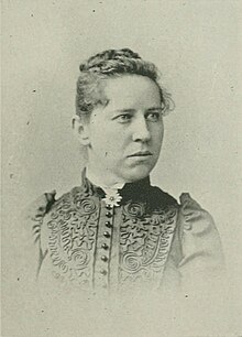 19th-century B&W portrait photo of a woman with her hair in an up-do, wearing a dark blouse.