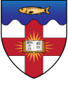 A shield displaying a coat of arms. A variation on the coat of arms of London University. Argent on a cross gules an open Bible proper irradiated or the pages inscribed with the words DOMINUS JESUS in letters sable on a chief wavy azure fish or.
