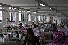 Women working at sewing machines in a large room