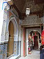 A lesser doorway to the zawiya in its southeastern corner, surrounded by painted wood, carved stucco, and zellij