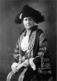 Sitting women in mayoral robes and chains, holding a scroll