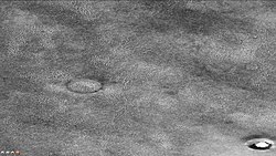 菲利普斯陨击坑显示多边形地块间的裂缝中有冰，请注意，这是前一幅背景相机所拍摄图像的放大。