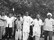 A. K. Gopalan and Harkishan Singh Surjeet standing next to Hare Krishna Konar who is giving speech
