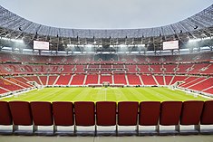 Photograph of a modern football stadium's interior; the stands are full of spectators