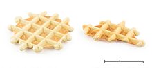 Small, round, light-brown waffles with irregular shaped edges