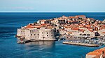 A view of Dubrovnik from the coast, showing defensive walls and a marina