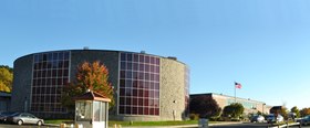 A high-school building, with a round auditorium in the foreground and a two-story rectangular brick building in the background