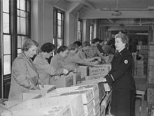 Ladies in a warehouse assembling care packages for soldiers
