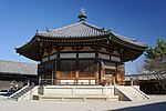 Large octagonal wooden building with white walls.