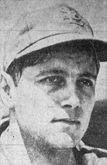 A man wearing a dark baseball cap looks to the right.