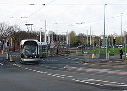 A city-bound tram has just left the stop and crossed the out-of-city track