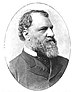 Profile of a white man with curly hair, a receding hairline, and a full beard, wearing a suit coat over a shirt and tie.