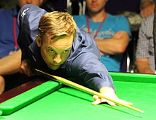 Ali Carter leaning over a table while lining up a shot