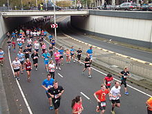 Photo of a group of runners passing underneath a viaduct