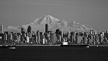 Black and white picture of the downtown Vancouver cityscape, a mountain in seen in the background.