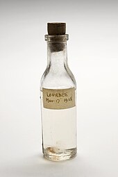 Glass bottle of water, label reads Lourdes, 1928
