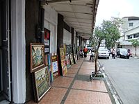 Kaki lima or five-foot way along Braga Street in Bandung, Indonesia, occupied by street artist selling paintings