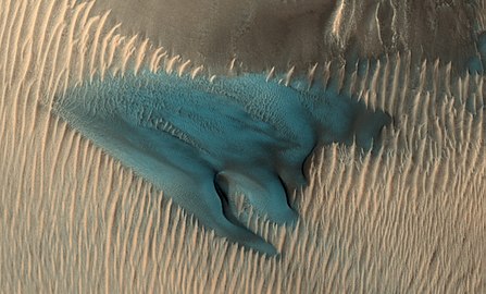 A dune on Mars appears in false colors blue. In false colour colours yellow to blue represent warmer to colder soil.[53]