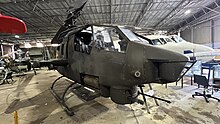 A picture of a Bell AH-1 Huey Cobra parked inside the HARS Parkes Aviation Museum.