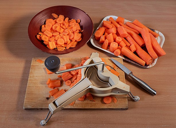 图为正在使用万能牌切片器切胡萝卜。