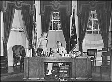 Franklin D. Roosevelt sitting at a large desk in the Oval Office