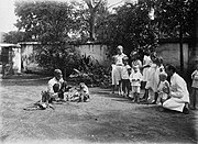 经过训练的猴在一群儿童面前表演 (约1900–1920）.