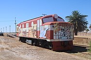 NSU60: sealed body shell on bogies at Marree, 2021. As decoration, the Marree Progress Association commissioned artwork with an Outback theme.