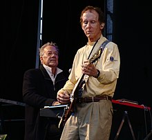 Krieger performing guitar onstage in front of Manzarek, seated at a keyboard