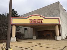 An abandoned movie theater. Present is signage reading "Rolling Acres Cinema"