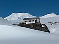 The main building of St. Kliment Ohridski Base, with Balkan Snowfield in the middle, and (left to right) Mount Friesland, St. Boris Peak and Simeon Peak in the background