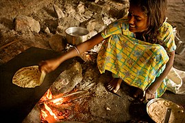 A girl baking chapatis in the traditional way