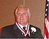 man in business suit wearing medal around neck