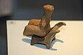 A clay model of a figurine in a chair