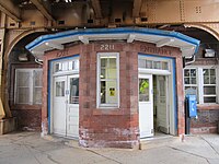 A front-bayed brick building with faded brick and white doors