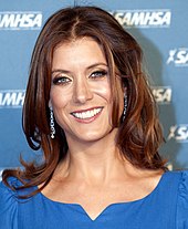 Kate Walsh smiling at the camera in a blue dress