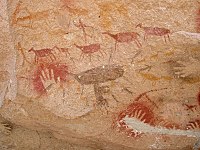 Photograph of drawings of a hunting scene with red animals