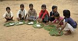 FE7. Schoolchildren in Chambal, Madhya Pradesh eating a mid-day meal. Half of the children in India are underweight, and 46% of children under the age of three suffer from malnutrition. The Mid-Day Meal Scheme attempts to lower these rates.