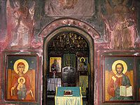 In the narthex of a small Orthodox church in Romania, looking through the doorway into the nave and Holy Doors.