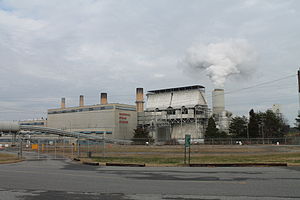 A steam station with a large cooling tower expelling a cloud of vapor