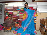 K-21 A shopkeeper in Lucknow models a sari for a customer.