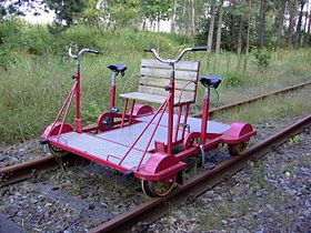 Rail-cycle with 4 wheels. A single bicycle may also be modified with an outrigger and locating wheels to operate upon rails