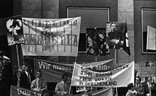 Marchers carry banners and enlarged photographs of victims at a protest in Stuttgard