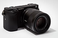 Sony Alpha ILCE-6300 APS-C-frame camera (mirrorless interchangeable-lens camera) with Zeiss lens Sonnar T* FE 1,8/55 ZA attached.