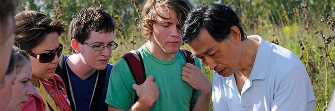 A biology class studying flora at a prairie, College of DuPage, United States