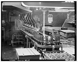 machinery with glassware on it in front and conveyor in back