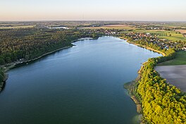 Green fields on the sides and a body of water in the middle under a clear sky.