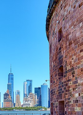 Part of the round wall of Castle Williams on Governor's Island with a view on Manhattan's financial district.