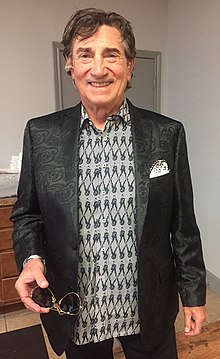A man wearing a black and white shirts and black jacket